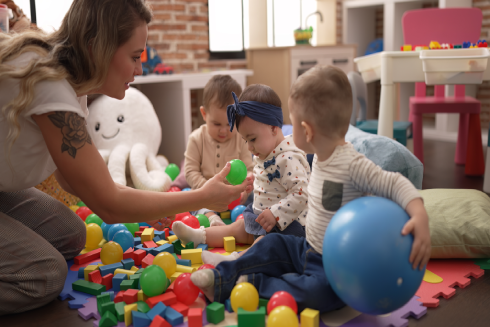 teacher-preschool-students-playing-with-balls-sitting-floor-kindergarten